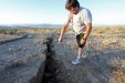 A Man Looks Into A Fissure That Opened In The Desert During A Powerful Earthquake That Struck Southern California, Near The City Of Ridgecrest